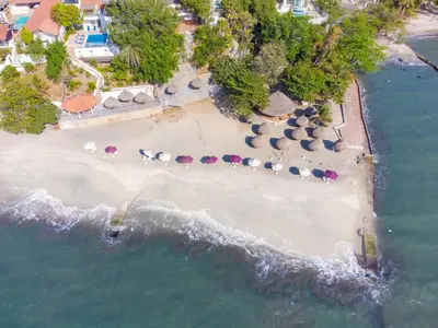 an aerial view of a beach with umbrellas and the ocean at Hotel Santorini Casablanca Resort in Santa Marta