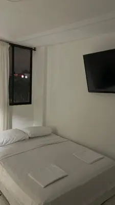 a white bedroom with a bed and a flat screen tv at Apartamento en el Norte a 5 Minutos de Buenavista in Barranquilla
