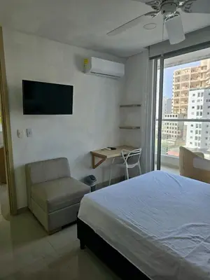 a bedroom with a bed and a chair and a television at Incredible apartment in Cartagena a few meters from the Sea in Cartagena de Indias