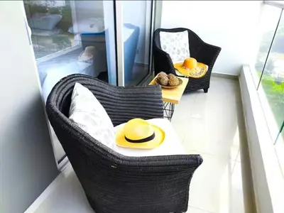 a balcony with two chairs and a table with a hat at Incredible apartment in Cartagena a few meters from the Sea in Cartagena de Indias