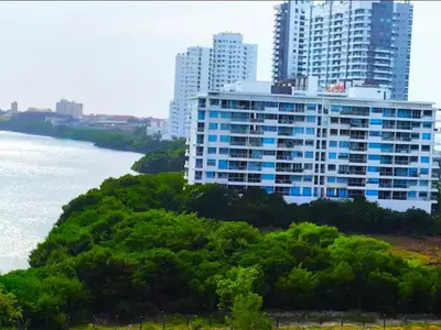 a large building with trees in front of a river at Incredible apartment in Cartagena a few meters from the Sea in Cartagena de Indias