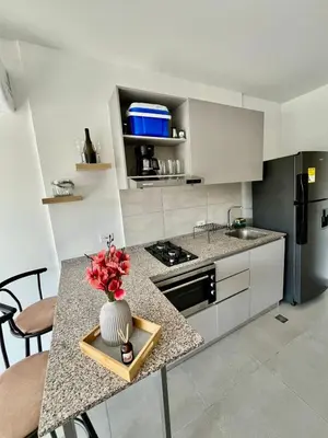 a kitchen with a vase of flowers on a counter at Loft cerca a la playa en Santa Marta Wi-Fi- Santa Marina in Santa Marta