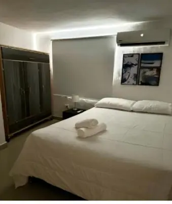 a bedroom with a white bed with a towel on it at Apartamento en Cartagena Manga 3 Habitaciones - Bahia in Cartagena de Indias