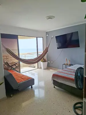a bedroom with two beds and a hammock in it at Relajación y vista al mar en hermoso apartamento en Cartagena in Cartagena de Indias