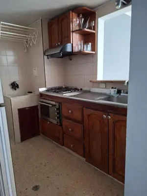 a kitchen with wooden cabinets and a stove top oven at Relajación y vista al mar en hermoso apartamento en Cartagena in Cartagena de Indias