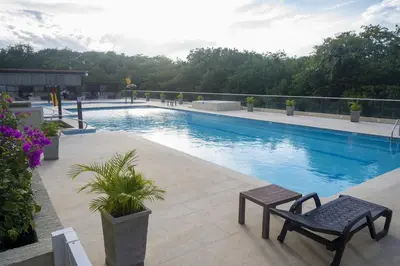 a swimming pool on top of a building with a bench at Ocean View Apartment - Soho Playa Mendoza in Tubará