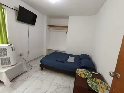 a small bedroom with a bed and a tv at Apartamentos Puerto Colombia Atlántico-Sabanilla in Maizal