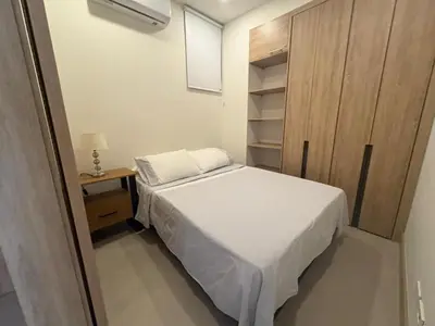 a small bedroom with a bed and a night stand at Apt 2 rooms with private beach and ideal pool in Cartagena de Indias