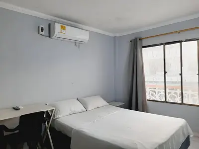 a room with two beds and a desk and a window at Hotel Tres Estrellas Fundacion in Fundación