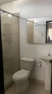 a bathroom with a toilet and a sink and a mirror at Hotel Tres Estrellas Fundacion in Fundación