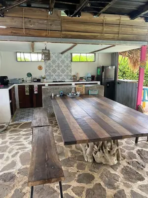 a large wooden table with two benches in a kitchen at Riders Shared Room en Mojarra Beach in Salina de Rey