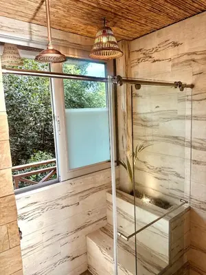 a glass shower in a bathroom with a window at Mero Beach - Apartamento frente al mar en Tolú in San Silvestre