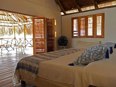 a bedroom with a bed with a view of a patio at Suemar Cabaña de Playa en Isla de Tierra Bomba in Cartagena de Indias