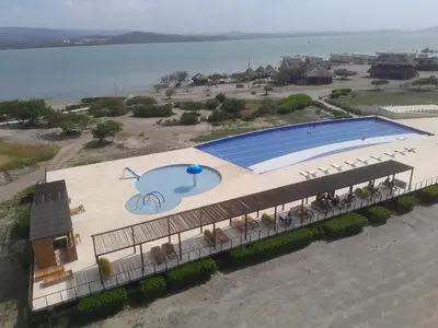 an overhead view of a swimming pool next to the water at Marina Puerto Velero Cabaña in Tubará
