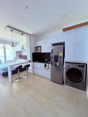 a kitchen with a refrigerator and a table in it at Cartagena Beach exclusive & Resort in Cartagena de Indias