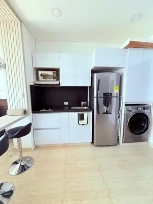 a kitchen with white cabinets and a stainless steel refrigerator at Cartagena Beach exclusive & Resort in Cartagena de Indias