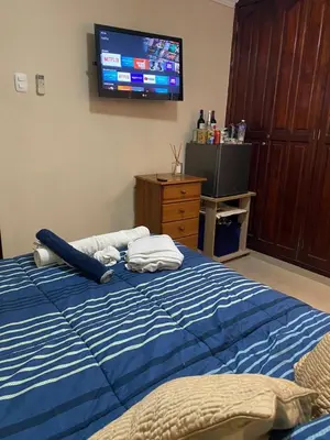 a bedroom with a bed with a tv on the wall at hermosa habitacion in Barranquilla