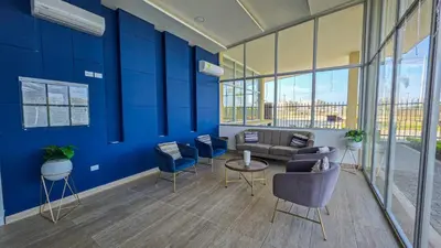 a lobby with blue walls and a couch and chairs at Capriella, Serena Del Mar in Cartagena de Indias