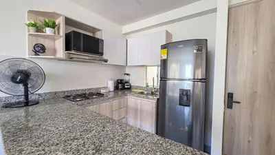 a kitchen with a stainless steel refrigerator and a fan at Capriella, Serena Del Mar in Cartagena de Indias