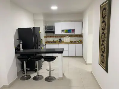 a kitchen with a black table and a refrigerator at Experience the magic of the Calle de las Damas historic center in Cartagena de Indias
