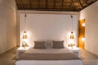 a bedroom with a large white bed with two lamps at Paradise Private Kaimari Ocean Villa in Cartagena de Indias