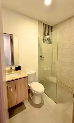 a bathroom with a toilet and a glass shower at Aqua Marine Suite - Santa Marina Condo in Santa Marta