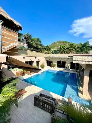 a swimming pool next to a building at Hermosa Villa de Lujo, De Kabaña in Santa Veronica