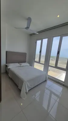 a bedroom with a bed with a view of the beach at Apto puerto velero in Barranquilla
