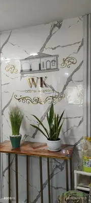 a table with two potted plants on a wall at Hotel WK Casa de Hospedaje in Barranquilla