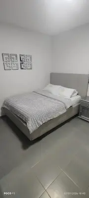 a bed in a room with a white wall at Hotel WK Casa de Hospedaje in Barranquilla