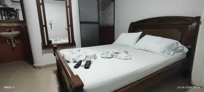 a bedroom with a bed with towels and a sink at Hotel WK Casa de Hospedaje in Barranquilla