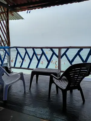 a balcony with two chairs and a table and a beach at Paraíso de corales in Playa Blanca