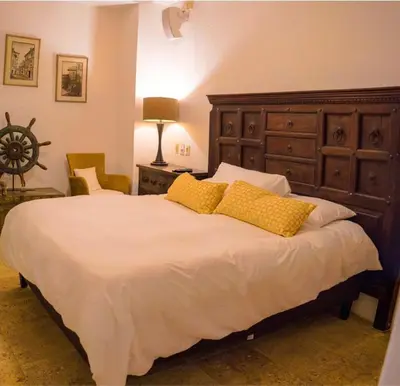 a bedroom with a large bed with two yellow pillows at Casa Del Hobo in Cartagena de Indias