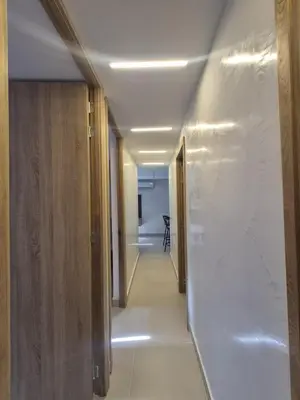a hallway with white walls and a long hallway with wooden doors at Precioso apartamento cerca del mar in Cartagena de Indias