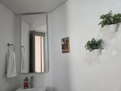 a white bathroom with a mirror and a sink at Brand New, Perfectly Located 2-2 in CieloMar! in Cartagena de Indias