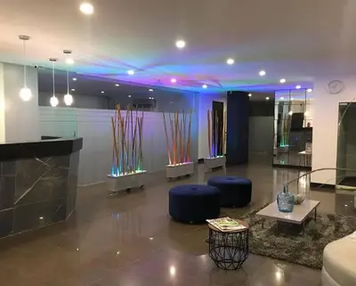 a lobby with blue lighting and blue chairs and tables at Apartasuites Amoblados Norte de Barranquilla-Atlantis Suites in Barranquilla