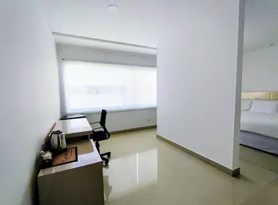 a room with a desk and a bed and a window at Apartasuites Amoblados Norte de Barranquilla-Atlantis Suites in Barranquilla