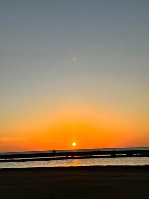 a sunset at the beach with a person in the water at Hostel cartagena in Cartagena de Indias