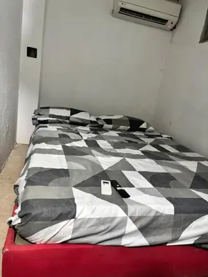 a bed with a black and white comforter in a room at Hostel cartagena in Cartagena de Indias