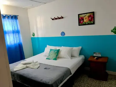 a bed in a room with a blue wall at Hotel Montecarlo by Croma in Santiago
