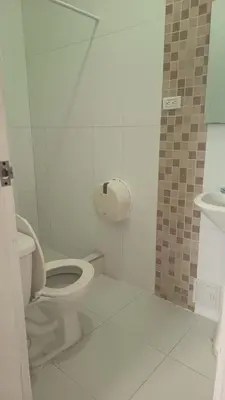 a white bathroom with a toilet and a sink at Hotel Montecarlo by Croma in Santiago