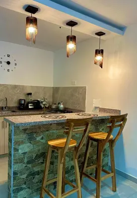 a kitchen with a counter with two stools at a bar at Coral del Mar 1 in Tolú