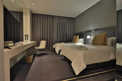 a hotel room with two beds and a desk at Movich Buró 51 in Barranquilla