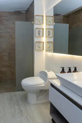 a white bathroom with a toilet and a sink at Luxury Apartment Suite Lake View 2 min Airport in Cartagena de Indias
