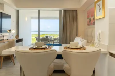 a dining room with a table and chairs with a view at Luxury Apartment Suite Lake View 2 min Airport in Cartagena de Indias