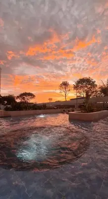a pool of water with a sunset in the background at Apartamento frente al mar- edificio santa marina in Santa Marta