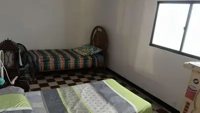 a room with a bed and a window and a couch at Habitacion en casa zona carnaval in Barranquilla