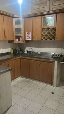 a kitchen with wooden cabinets and a sink at Habitacion en casa zona carnaval in Barranquilla