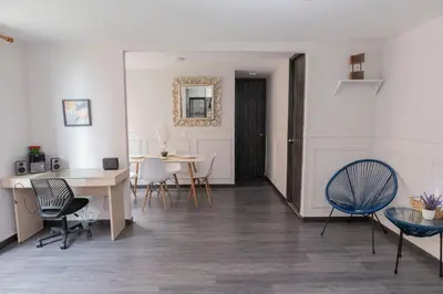 a living room with white walls and a table and chairs at Comodo apartamento en el norte de Barranquilla in Barranquilla