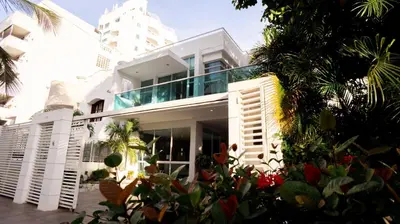 a white house with a lot of plants at MQ CROWN HOUSE CASTIllO in Cartagena de Indias